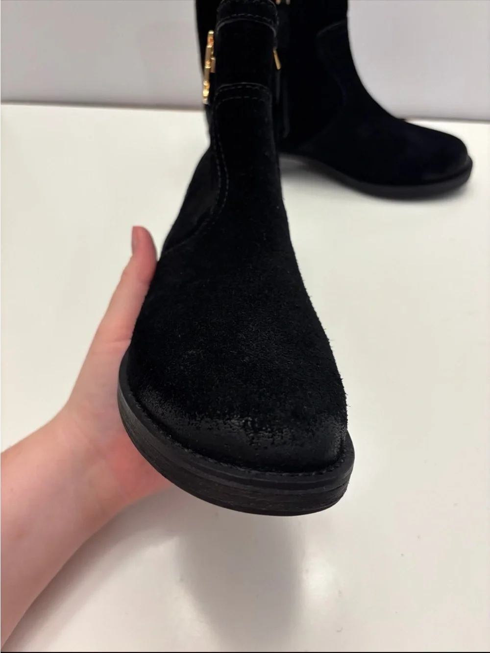 Tory Burch black suede Eloise flat booties with a prominent gold-tone metal logo